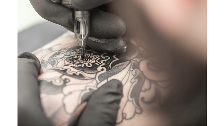 Tattooist drawing on arm of client