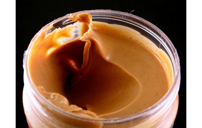 Close-up of an opened jar of creamy peanut butter