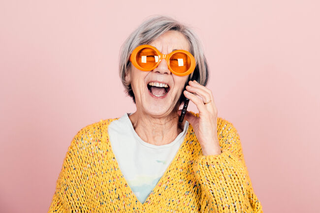 Happy Young Style Elderly Grandma With Orange Sunglasses And Modern Looking Laughing On The Phone