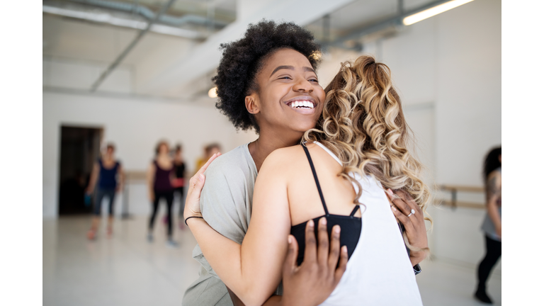 Dance instructor greeting students at fitness studio