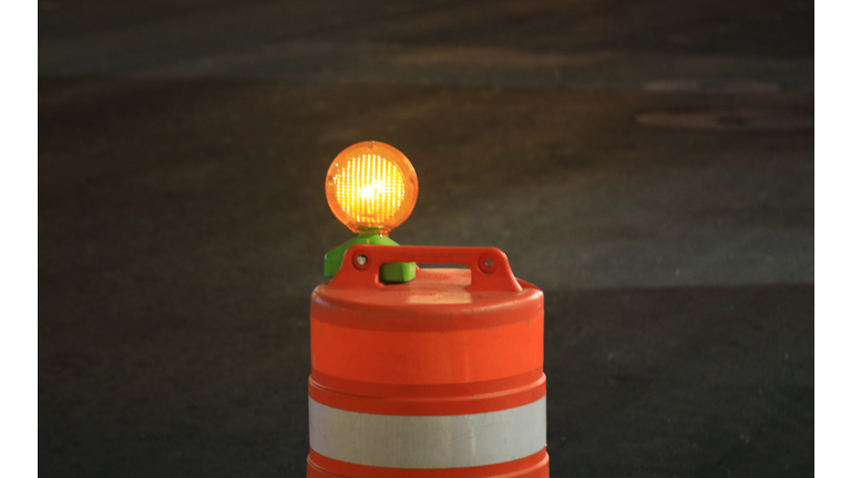 Orange roadway traffic barrel with safety light