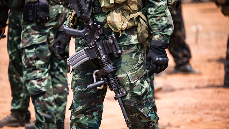 Midsection Of Army Soldiers With Rifle
