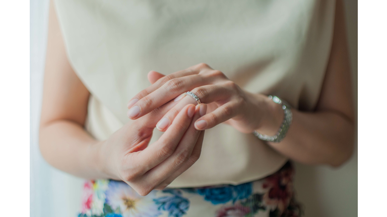 A young woman is wearing her wedding ring