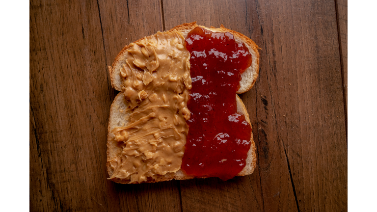 Open Face Peanut Butter and Jelly Sandwich on a Rustic Cutting Board