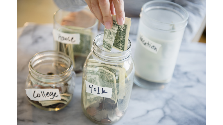 Mixed race woman saving money in jars