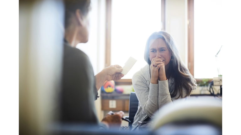 Therapist giving prescription to crying patient during session