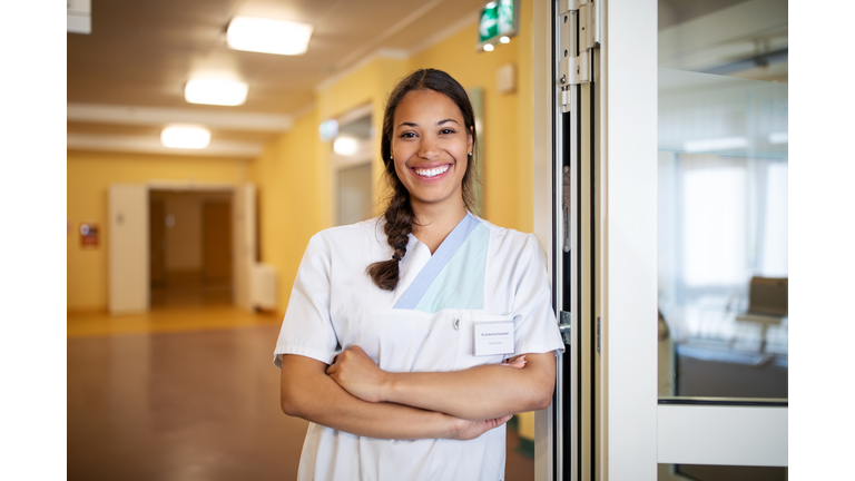 Portrait of confident female nurse at doorway