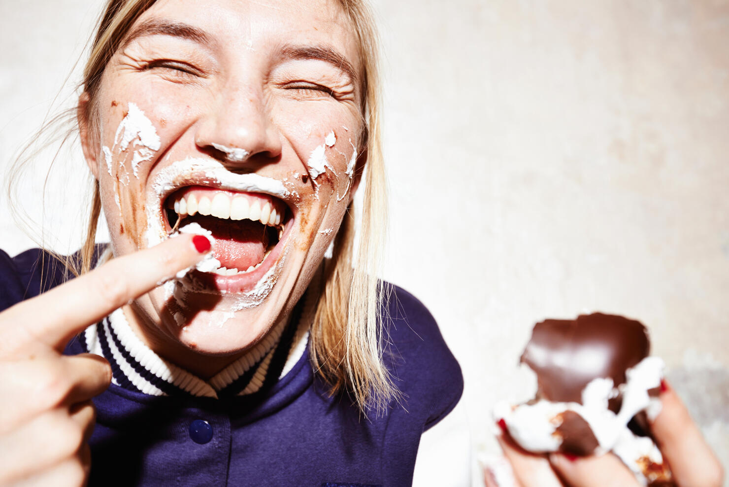 Close up studio shot of young woman with face covered in chocolate marshmallow