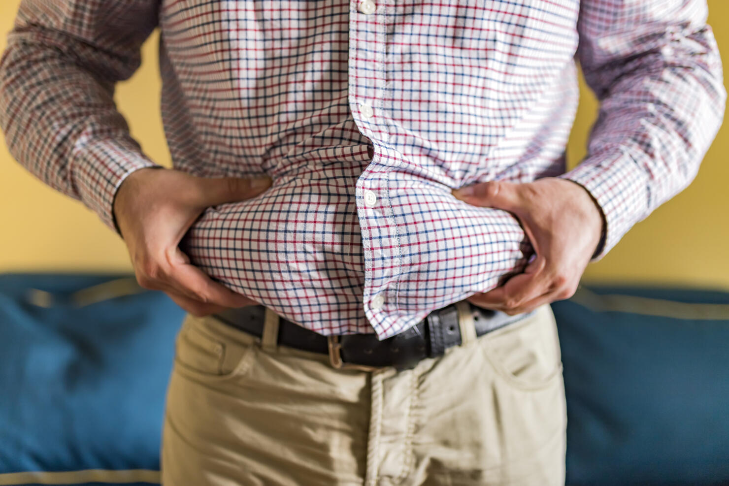 Midsection Of Man Holding Belly Fat At Home