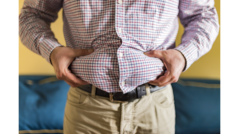 Midsection Of Man Holding Belly Fat At Home