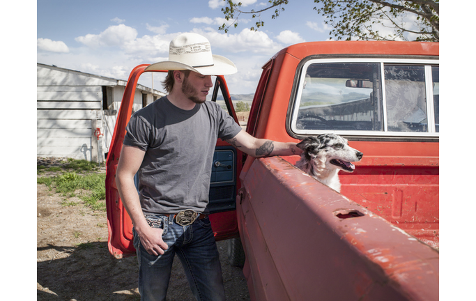 Young man in cowboy hat with pickup and dog
