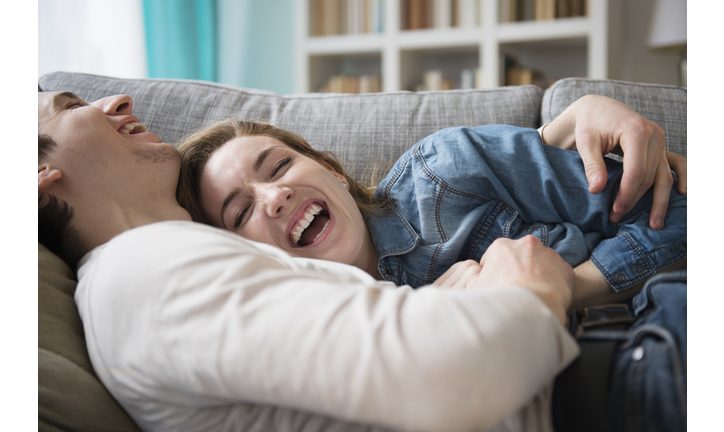 Couple laughing together on couch