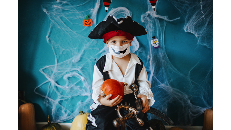 Little boy wearing Halloween costume and protective face mask during Covid-19 pandemic