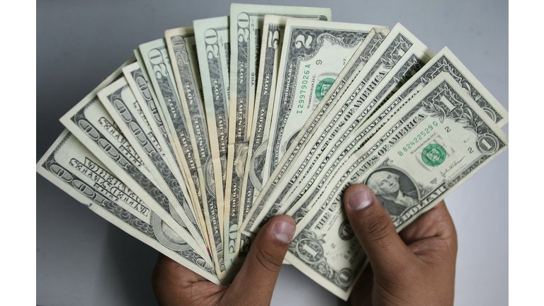 An Indian money changer poses as he coun