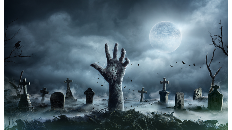 Zombie Hand Rising Out Of A Graveyard In Spooky Night