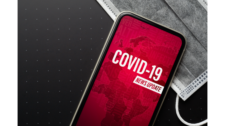 Coronavirus or Covid-19 outbreak News Update background concept. Mockup mobile phone Coronavirus News with facial masks. Flat lay top view with copy space.