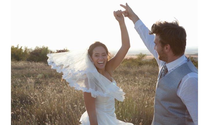 Newlywed couple dancing outdoors