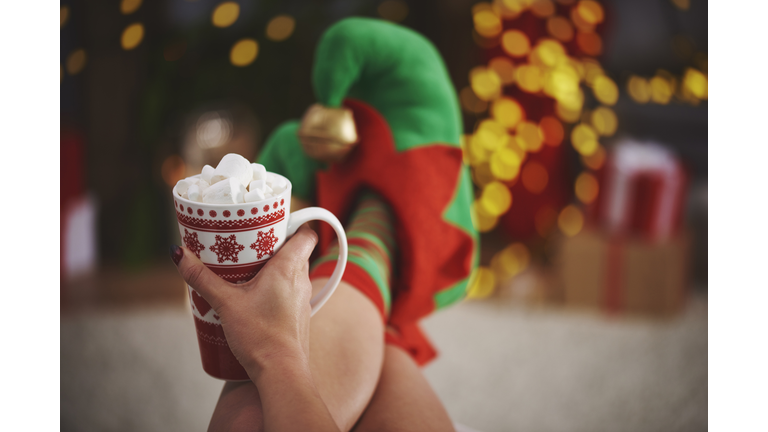 Woman wearing elf slippers holding hot chocolate