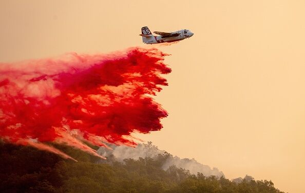 A CalFire airplane drops fire retardant over the Davis Winery during the Glass fire in Napa County's St. Helena, California on September 27, 2020.
