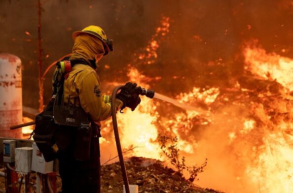 A Marin County firefighter douses flames during the Glass fire in St. Helena, California on September 27, 2020.