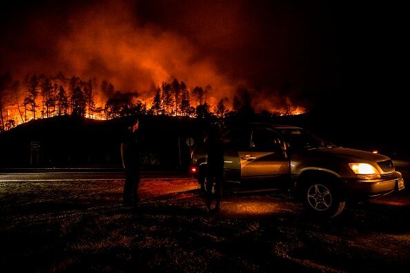 People stop on the side of the road to watch as the Glass Fire slowly blazes down the hill side outside of Calistoga in Napa Valley, California on September 28, 2020.