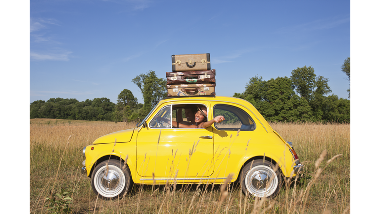 Couple in old-fashioned car on road trip