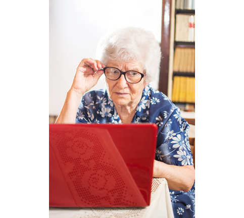 Confused grandmother using a laptop computer at home.