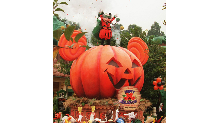 Mickey mouse appears atop a pumpkin float while re