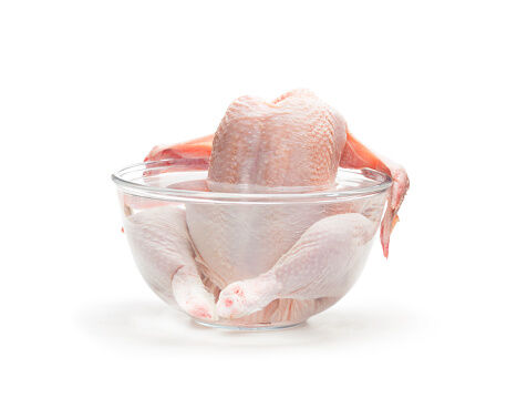 Raw  chicken in the water isolated on white background. Ready for cooking.