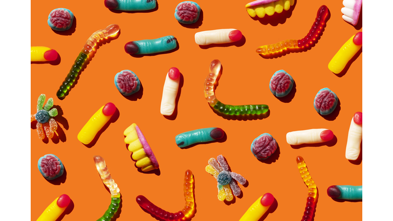 Halloween jelly beans, finger-shaped, brains, worm and vampire teeth on orange background