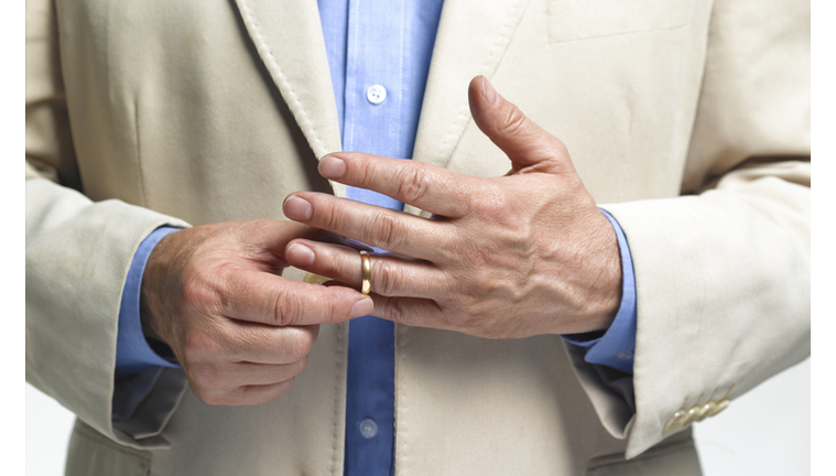 Divorced man taking off wedding ring