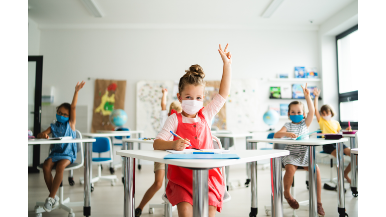 Small children with face mask back to school after coronavirus quarantine, learning.