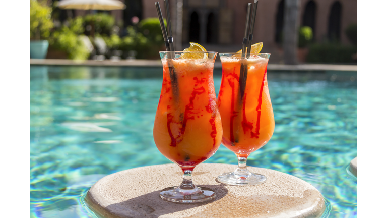 Fruity cocktails floating on swimming pool