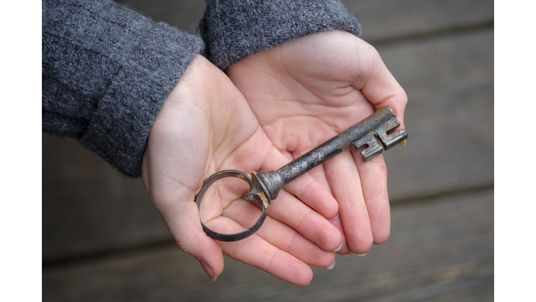 Hands holding an old key, close-up