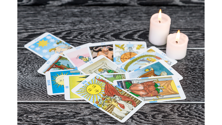 Close-Up Of Tarot Cards With Candles On Table