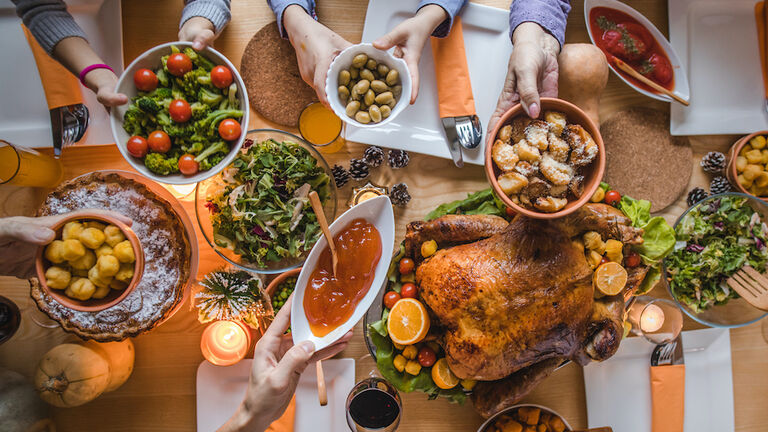 Above view of passing food during Thanksgiving dinner.
