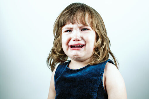 Crying toddler girl's studio portrait