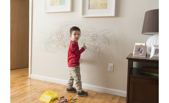 Boy drawing on wall with crayons