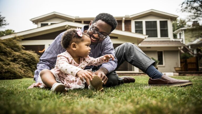 Father and daughter (18 months) playing in backyard