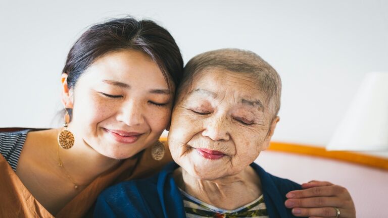 Portrait of old mother with cancer and her middle aged daughter