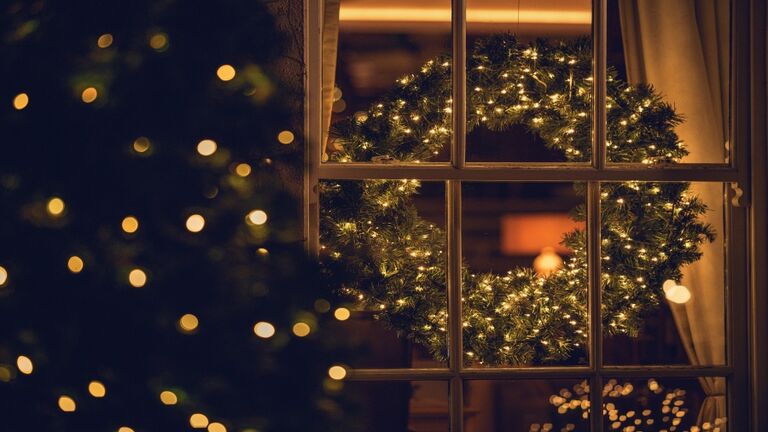 View through a window of a Christmas wreath in a living room