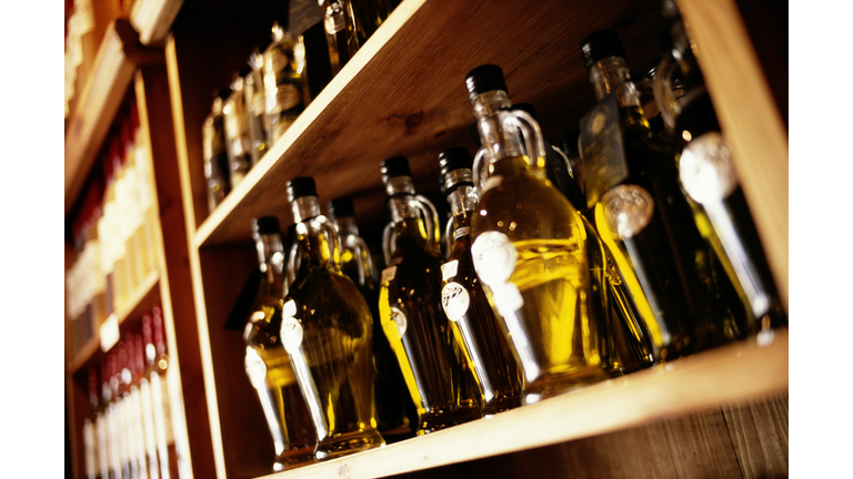 Bottles of olive oil on shop shelf, close-up