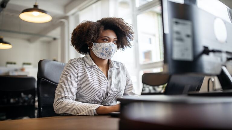 Businesswoman with face mask working at her desk