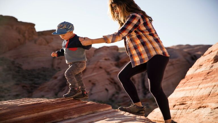 A mother and her young son hiking in the desert