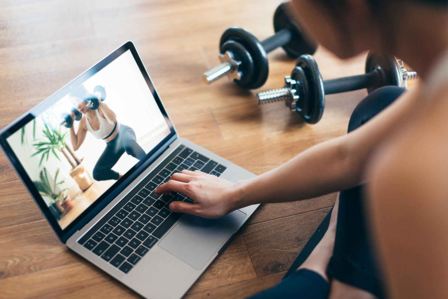 Young Woman Practising Weight Training Workout With A Video Lesson On Laptop.