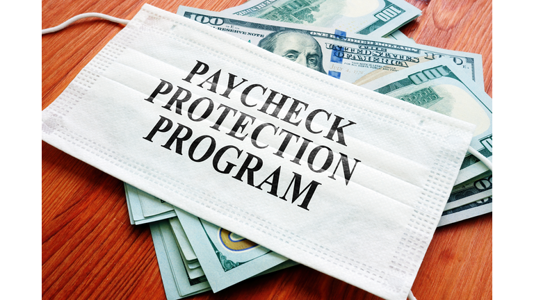 PPP Paycheck Protection Program as SBA loan written on the mask and money.