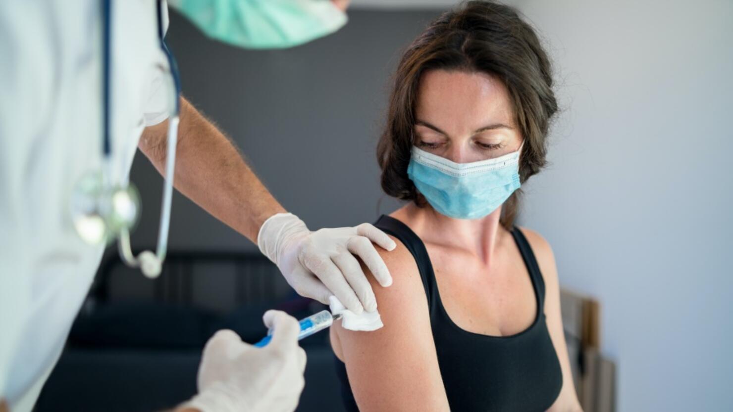 Woman with face mask getting vaccinated, coronavirus concept.