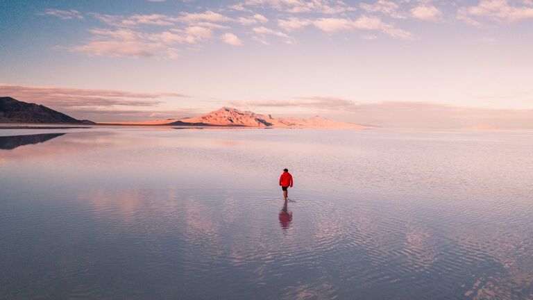 Aerial shot of a person walking across the flooded Bonneville salt flats, Utah, United States of America