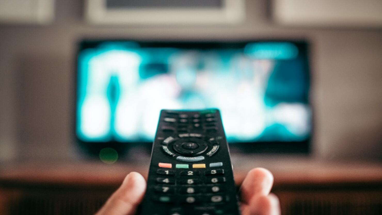 Close-Up Of Hand Holding Remote Control At Home