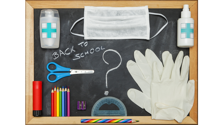 Back to School items and COVID-19 protective equipment on a blackboard